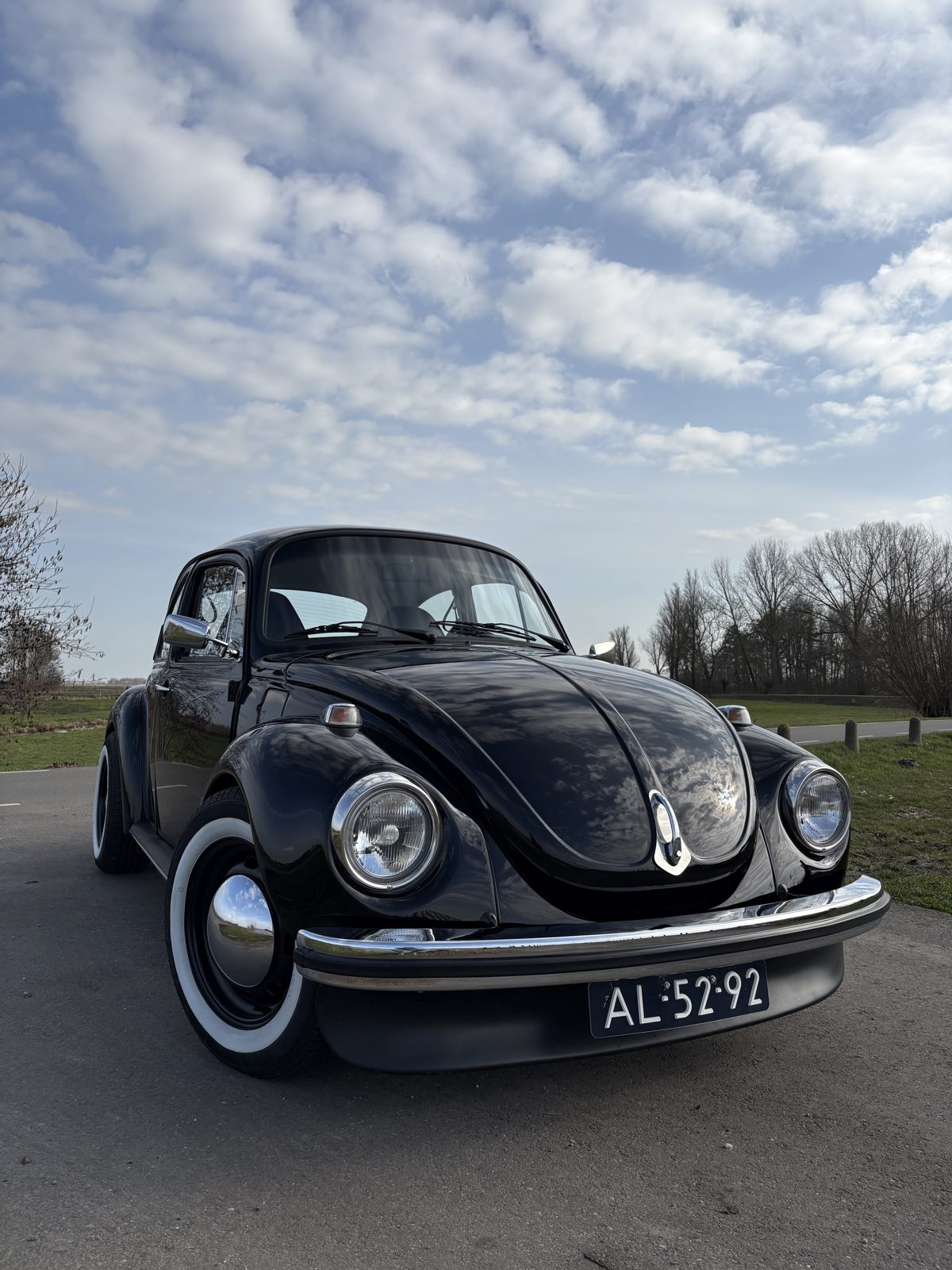 Jerry's black 1972 Volkswagen Beetle with whitewall tyres, on a country road under a cloudy sky